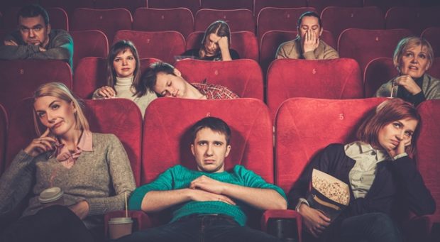 Group of people watching boring movie in cinema